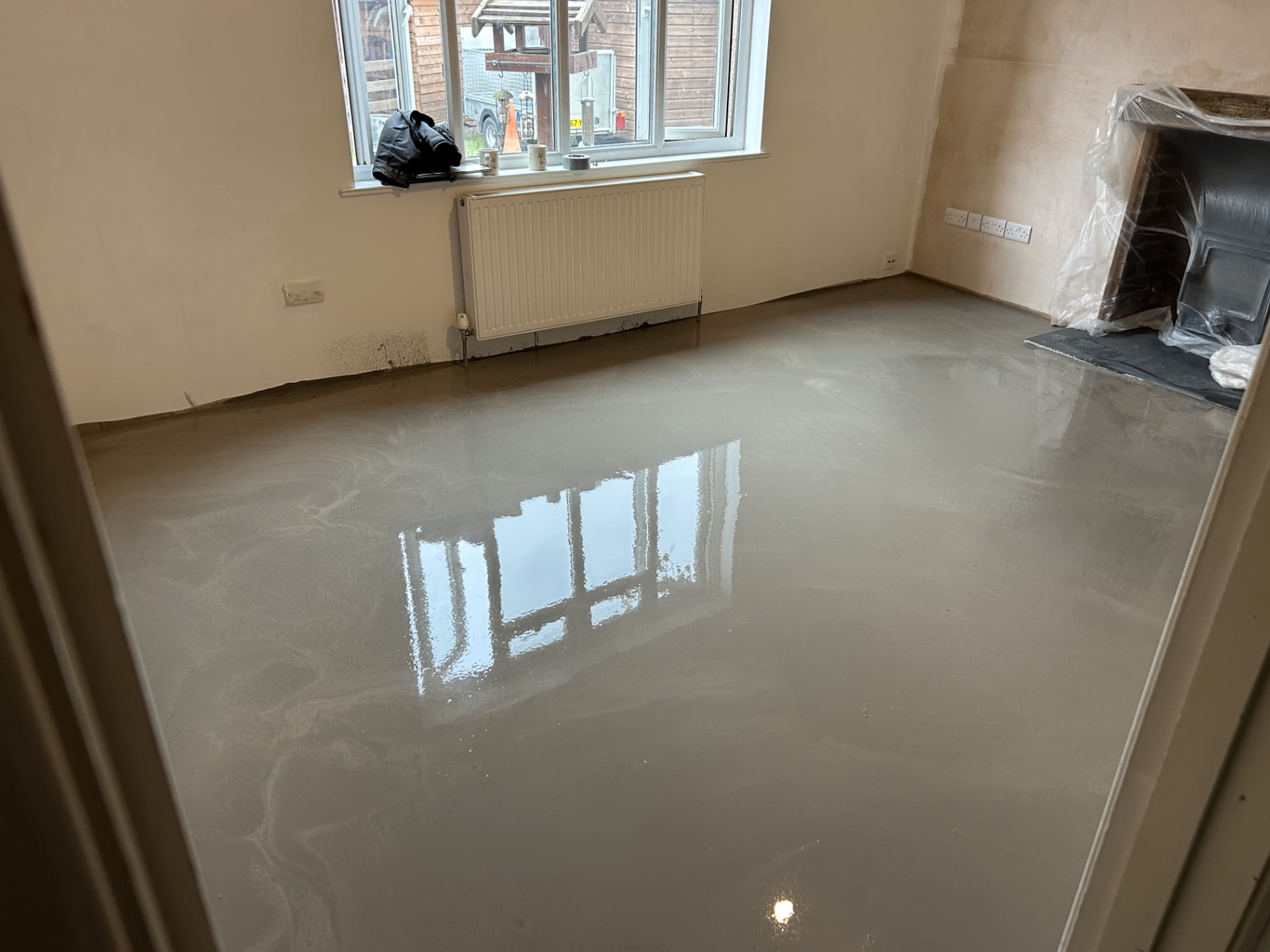 Bright room with newly laid liquid screed reflecting window light